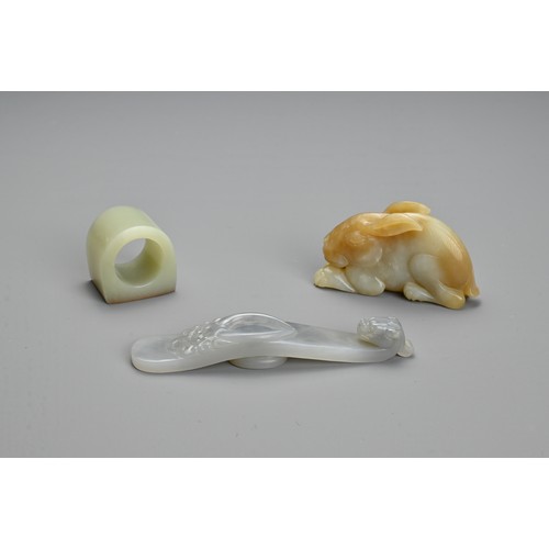 76 - THREE CHINESE CARVED JADE ITEMS. To include a pendant in the form of a hare; A thumb ring; Together ... 