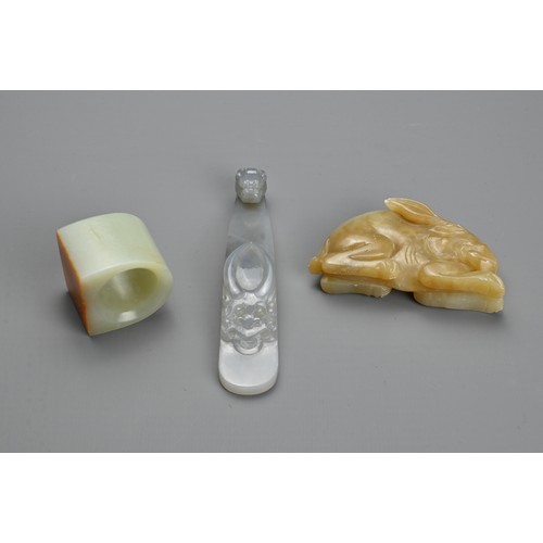 76 - THREE CHINESE CARVED JADE ITEMS. To include a pendant in the form of a hare; A thumb ring; Together ... 