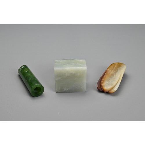 77 - THREE CHINESE CARVED JADE ITEMS. To include a square seal surmounted by an elephant and incised four... 