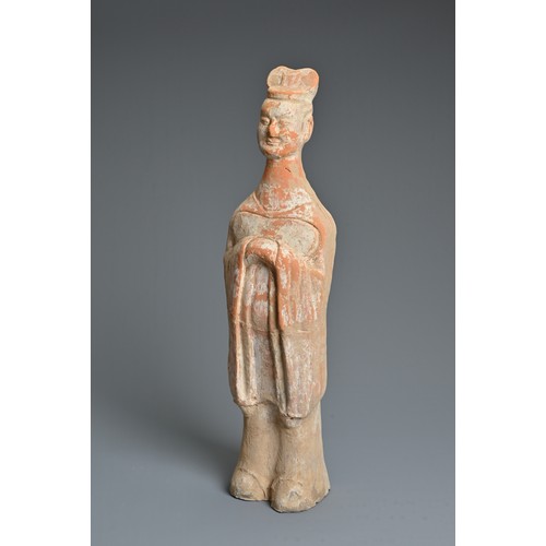 171 - A CHINESE TANG DYNASTY (AD 618-907) PAINTED POTTERY FIGURE OF AN ATTENDANT, the solid figure modelle... 