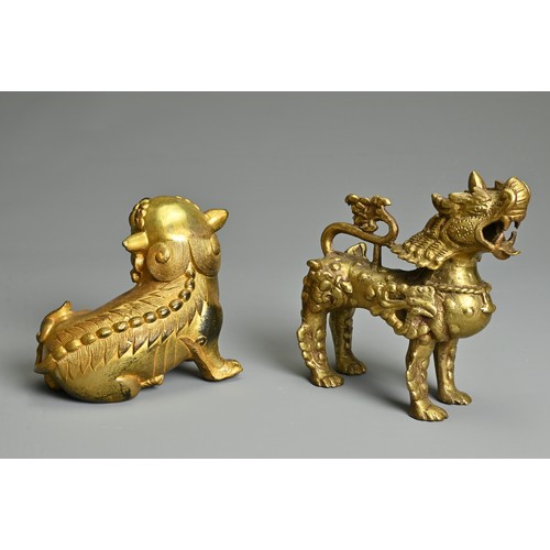 180 - A CHINESE GILT-BRONZE MODEL OF A SEATED LION, A GILT-METAL LION, PROBABLY TIBETAN AND TWO SEALS, the... 