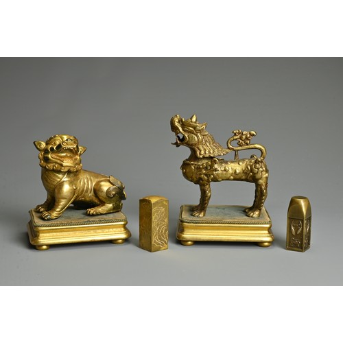 180 - A CHINESE GILT-BRONZE MODEL OF A SEATED LION, A GILT-METAL LION, PROBABLY TIBETAN AND TWO SEALS, the... 