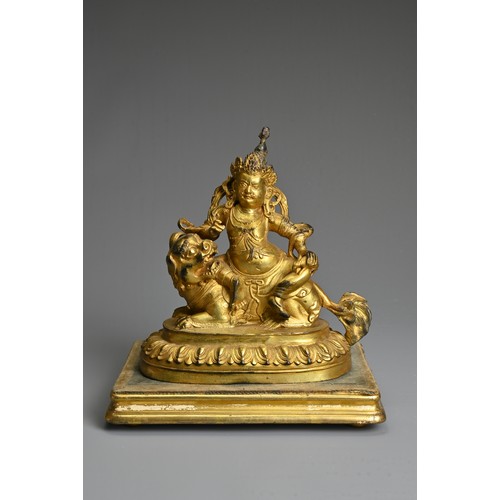 181 - A SINO-TIBETAN GILT-BRONZE FIGURE OF VAISHRAVANA, cast seated atop a lion holding a rat in his left ... 