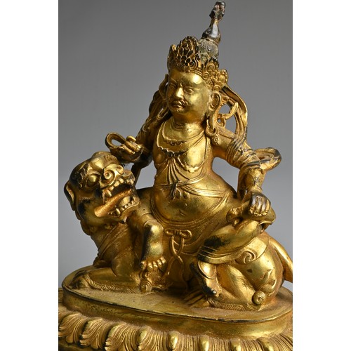 181 - A SINO-TIBETAN GILT-BRONZE FIGURE OF VAISHRAVANA, cast seated atop a lion holding a rat in his left ... 