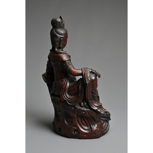 179 - A CHINESE PATINATED BRONZE MODEL OF A SEATED GUANYIN. In dark-brown patination, cast reclining on dr... 