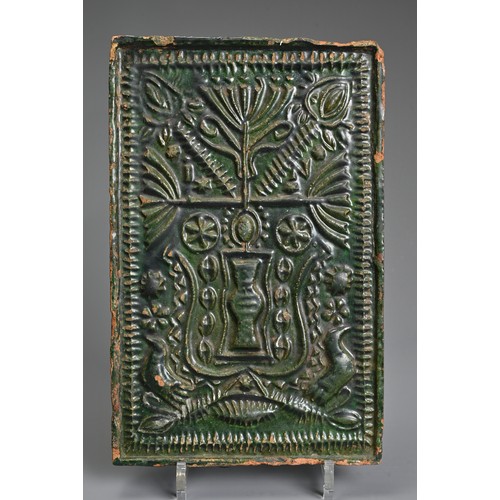 267 - A GREEN-GLAZED POTTERY STOVE TILE, PROBABLY GERMAN AND 16TH CENTURY OR LATER. Moulded with vase issu... 