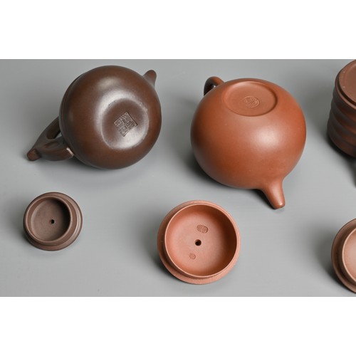 38 - FOUR CHINESE YIXING POTTERY TEAPOTS, 20TH CENTURY OR LATER. Of varying sizes and forms each with mak... 