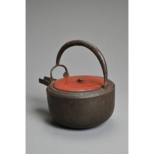 238 - A 20TH CENTURY JAPANESE CAST IRON CHOSHI (SAKE EWER), set on tripod feet with red lacquered wood cov... 