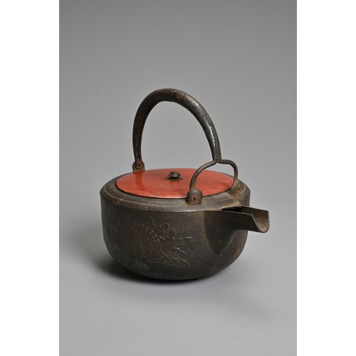 238 - A 20TH CENTURY JAPANESE CAST IRON CHOSHI (SAKE EWER), set on tripod feet with red lacquered wood cov... 