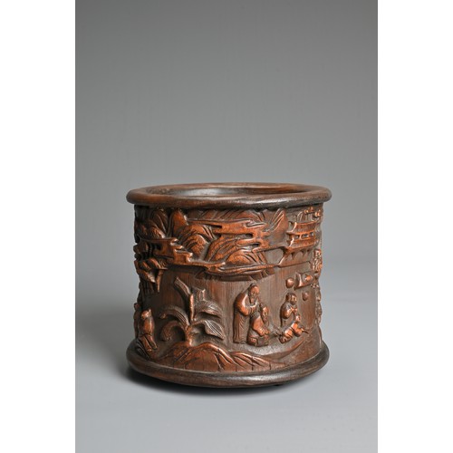 104 - A CHINESE BAMBOO BRUSH POT. Decorated in relief with figures in a courtyard scene inscribed near bas... 