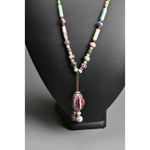 279 - THREE NECKLACES. To include a ceramic beaded necklace; A jade stone beaded necklace mounted with sil... 