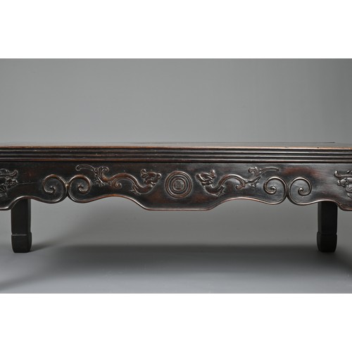 204 - A CHINESE HARDWOOD LOW RECTANGULAR TABLE, QING DYNASTY. The frieze carved with bats, ruyi clouds, dr... 