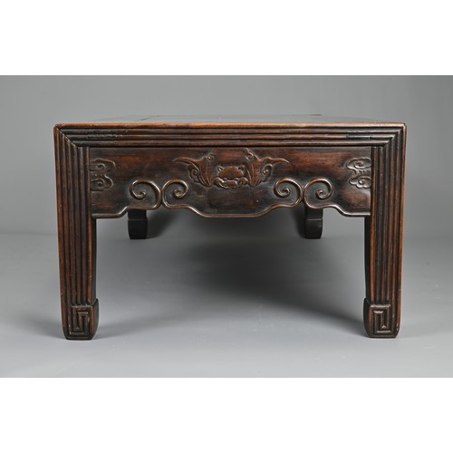 204 - A CHINESE HARDWOOD LOW RECTANGULAR TABLE, QING DYNASTY. The frieze carved with bats, ruyi clouds, dr... 