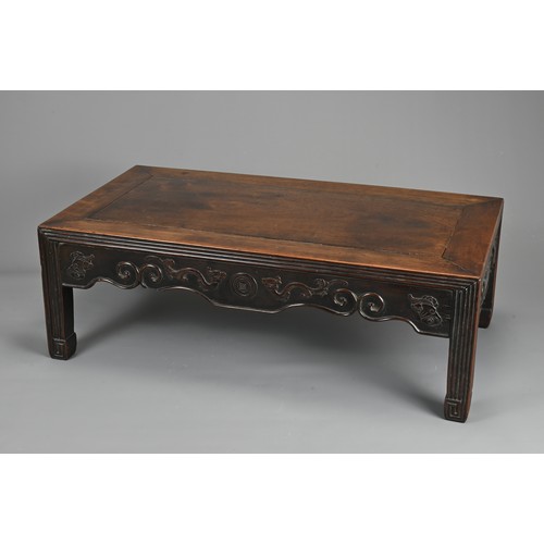 204 - A CHINESE HARDWOOD LOW RECTANGULAR TABLE, QING DYNASTY. The frieze carved with bats, ruyi clouds, dr... 