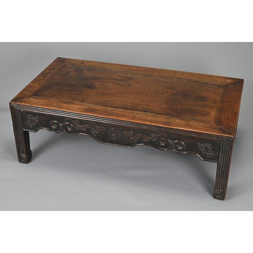 204 - A CHINESE HARDWOOD LOW RECTANGULAR TABLE, QING DYNASTY. The frieze carved with bats, ruyi clouds, dr... 