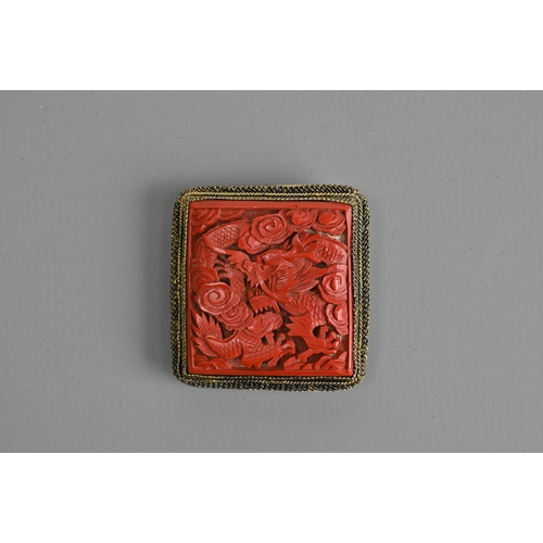 227 - A CHINESE RED LACQUER DRAGON BROOCH, EARLY 20TH CENTURY. Of square form featuring a dragon amidst cl... 