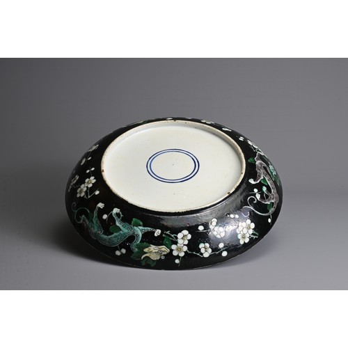 16 - A CHINESE FAMILLE NOIRE PORCELAIN DRAGON DISH, 19/20TH CENTURY. Decorated with three dragons in yell... 