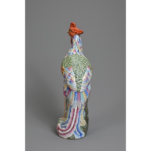 30 - A CHINESE FAMILLE ROSE PORCELAIN MODEL OF A PHOENIX. Modelled standing on a rockwork base with peony... 