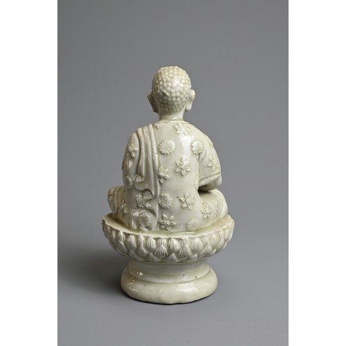 44 - AN UNUSUAL CHINESE PALE CELADON GLAZED PORCELAIN FIGURE OF BUDDHA, 17/18TH CENTURY. Seated on a rais... 