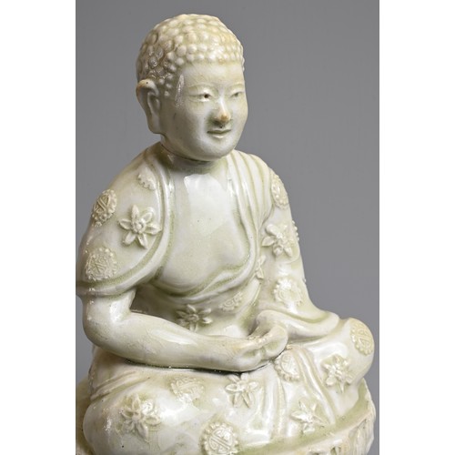 44 - AN UNUSUAL CHINESE PALE CELADON GLAZED PORCELAIN FIGURE OF BUDDHA, 17/18TH CENTURY. Seated on a rais... 