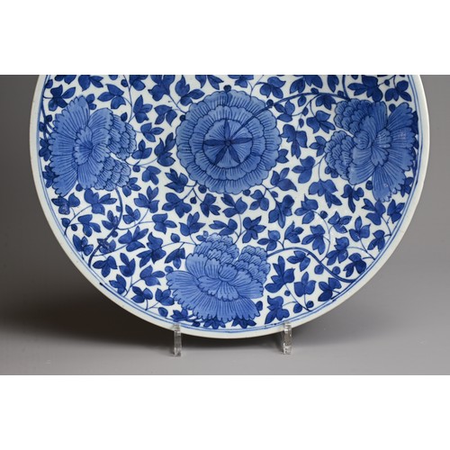 60 - A LARGE CHINESE BLUE AND WHITE PORCELAIN DISH, QING DYNASTY. Decorated with large peony blooms with ... 