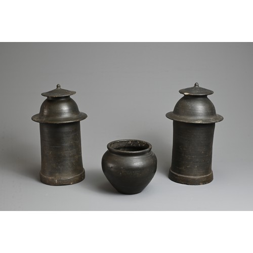 210 - THREE RARE CHINESE BURNISHED BLACK POTTERY JARS, YUAN DYNASTY (1279 – 1368). Comprising two tall cyl... 