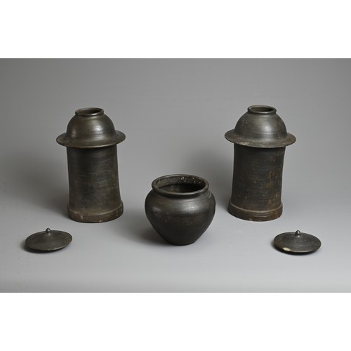 210 - THREE RARE CHINESE BURNISHED BLACK POTTERY JARS, YUAN DYNASTY (1279 – 1368). Comprising two tall cyl... 