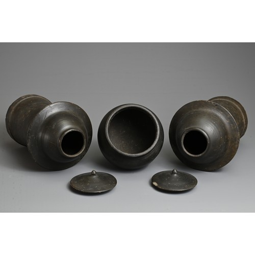 210 - THREE RARE CHINESE BURNISHED BLACK POTTERY JARS, YUAN DYNASTY (1279 – 1368). Comprising two tall cyl... 