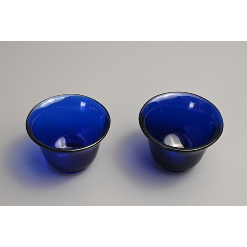 274 - A PAIR OF CHINESE BLUE PEKING GLASS WINE CUPS, LATE QING DYNASTY. Bell shaped cups on thick circular... 