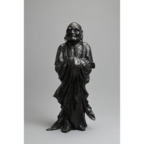 312 - A JAPANESE LATE MEIJI PERIOD (1868-1912) BRONZE OF A STANDING DARUMA BY HOZAN-ZUKURI. Cast standing ... 