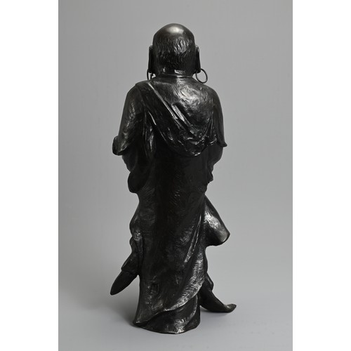 312 - A JAPANESE LATE MEIJI PERIOD (1868-1912) BRONZE OF A STANDING DARUMA BY HOZAN-ZUKURI. Cast standing ... 