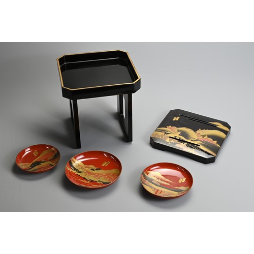 288 - A SET OF THREE 20TH CENTURY RED LACQUER JAPANESE SAKE CUPS (SAKAZUKI) AND A BLACK LACQUER TABLE (KAG... 