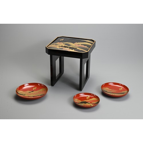 288 - A SET OF THREE 20TH CENTURY RED LACQUER JAPANESE SAKE CUPS (SAKAZUKI) AND A BLACK LACQUER TABLE (KAG... 