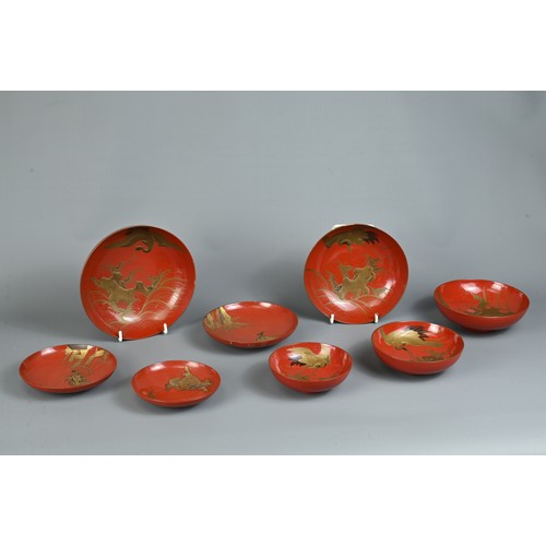 287 - A GROUP OF EIGHT 20TH CENTURY JAPANESE RED LACQUER SAKE CUPS IN SIZES. Decorated in gold maki-e on a... 