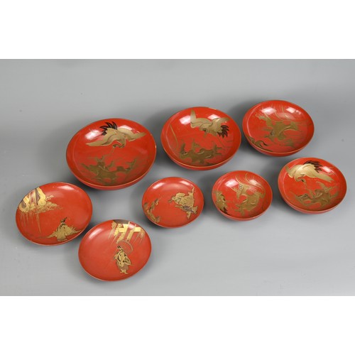 287 - A GROUP OF EIGHT 20TH CENTURY JAPANESE RED LACQUER SAKE CUPS IN SIZES. Decorated in gold maki-e on a... 