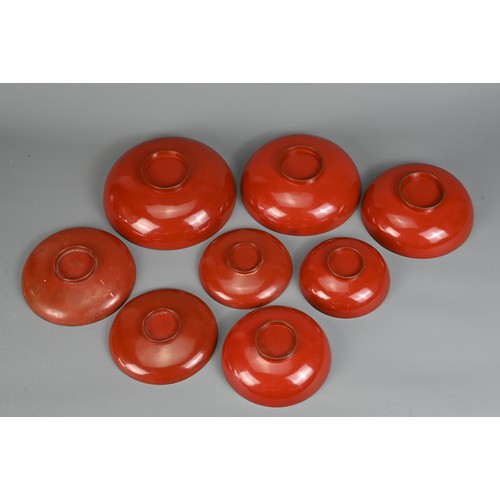 287 - A GROUP OF EIGHT 20TH CENTURY JAPANESE RED LACQUER SAKE CUPS IN SIZES. Decorated in gold maki-e on a... 