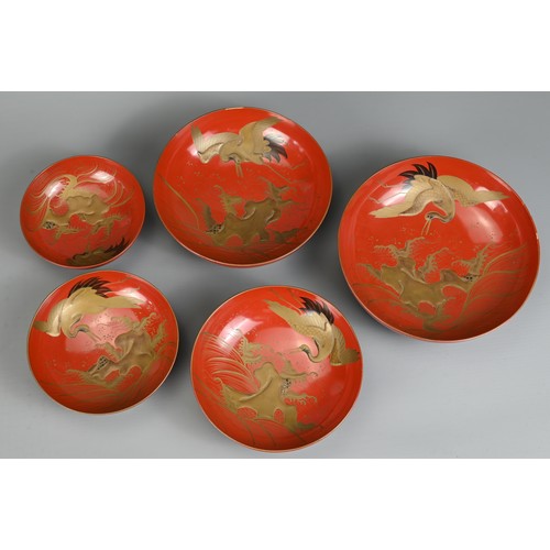 287 - A GROUP OF EIGHT 20TH CENTURY JAPANESE RED LACQUER SAKE CUPS IN SIZES. Decorated in gold maki-e on a... 