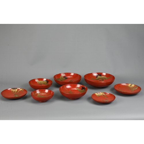 287 - A GROUP OF EIGHT 20TH CENTURY JAPANESE RED LACQUER SAKE CUPS IN SIZES. Decorated in gold maki-e on a... 