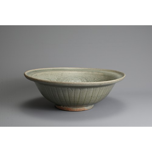 173 - A LARGE THAI SAWANKHALOK CELADON STONEWARE DISH, 14/15TH CENTURY. Heavily potted with flared upturne... 