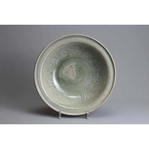 173 - A LARGE THAI SAWANKHALOK CELADON STONEWARE DISH, 14/15TH CENTURY. Heavily potted with flared upturne... 