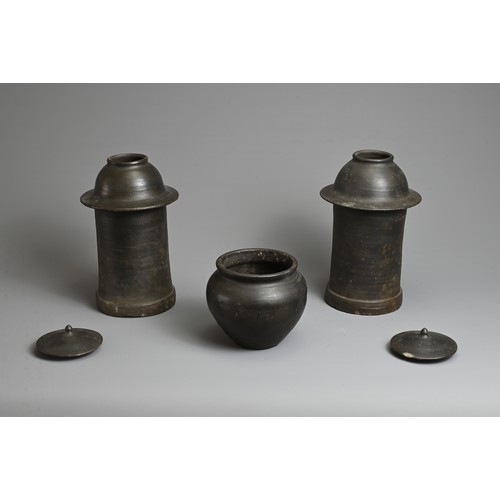 175 - THREE RARE CHINESE BURNISHED BLACK POTTERY JARS, YUAN DYNASTY (1279 – 1368). Comprising two tall cyl... 