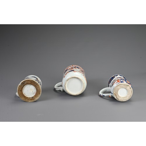 1 - THREE CHINESE IMARI PORCELAIN TANKARDS, 18TH CENTURY. Of varying sizes decorated with coastal and fl... 