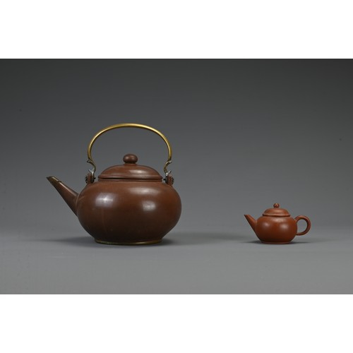 28 - TWO CHINESE YIXING POTTERY TEAPOTS, 19TH CENTURY AND LATER. The larger pot with bronze handle and tw... 