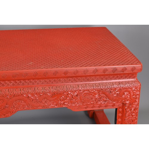 202 - A VINTAGE CHINESE CINNABAR LACQUER TYPE COFFEE-TABLE OF LOW ALTAR FORM. Carved with lozenge and flow... 