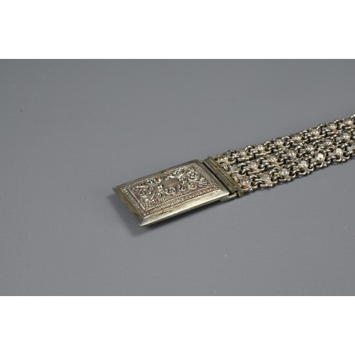 64 - A MIDDLE EASTERN METAL WARE BELT AND BUCKLES, 19/20TH CENTURY. To include a chain form belt with flo... 