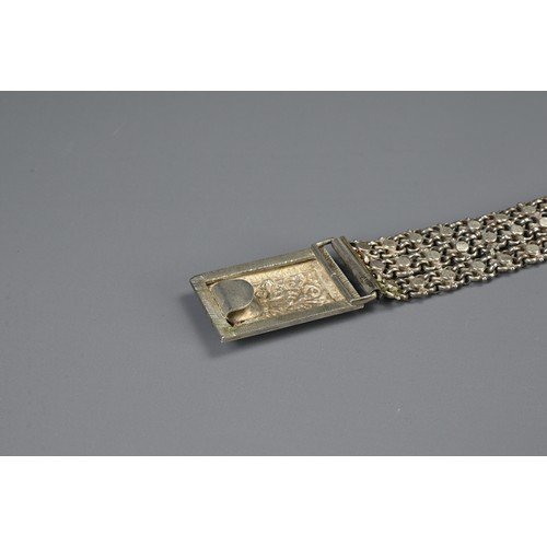 64 - A MIDDLE EASTERN METAL WARE BELT AND BUCKLES, 19/20TH CENTURY. To include a chain form belt with flo... 