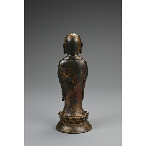 78 - A CHINESE BRONZE FIGURE OF LUOHAN. The figure dress in robes with his palms together on lotus stand.... 