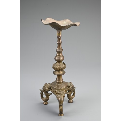 87 - A CHINESE BRONZE PRICKET CANDLESTICK, 20TH CENTURY. Raised on three lion form feet with single lotus... 