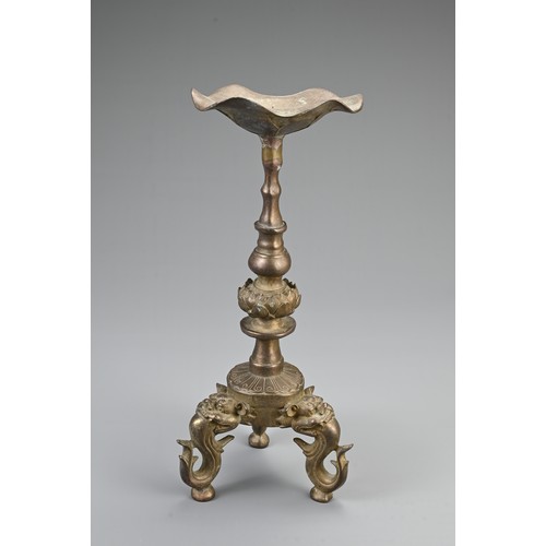 87 - A CHINESE BRONZE PRICKET CANDLESTICK, 20TH CENTURY. Raised on three lion form feet with single lotus... 