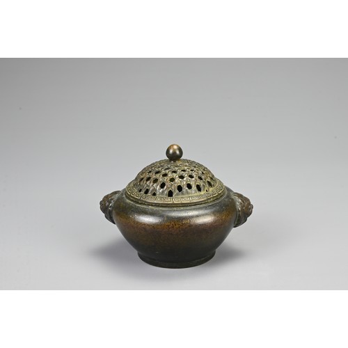 83 - A CHINESE BRONZE CENSER, 20TH CENTURY. Of circular form with twin lion mask handles and pierced cove... 